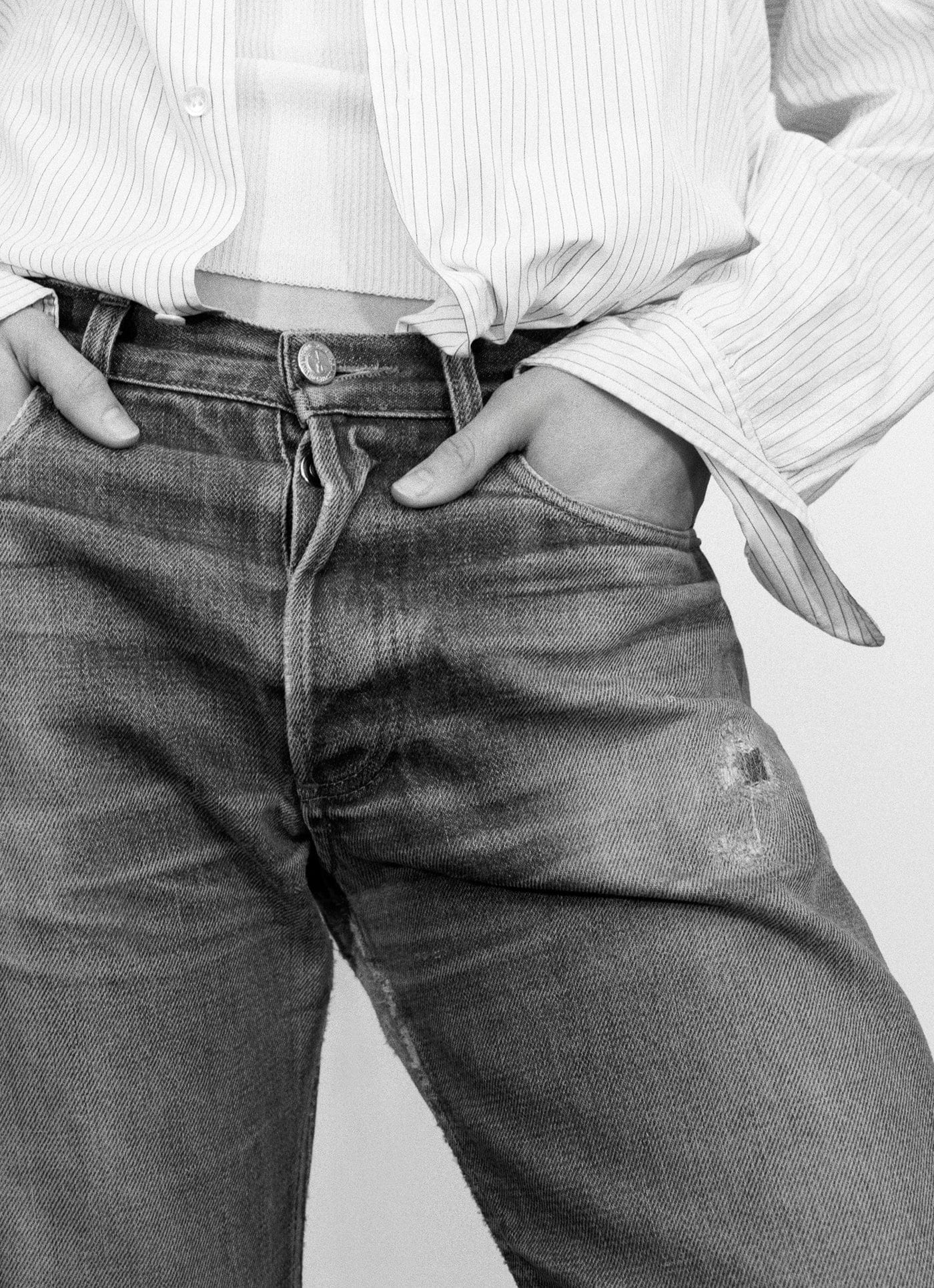 Gros plan sur un jean A.P.C. en denim brut délavé par l'usage, patine visible autour de la poche