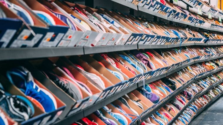 Long mur de sneakers alignées sur les étagères d'une boutique