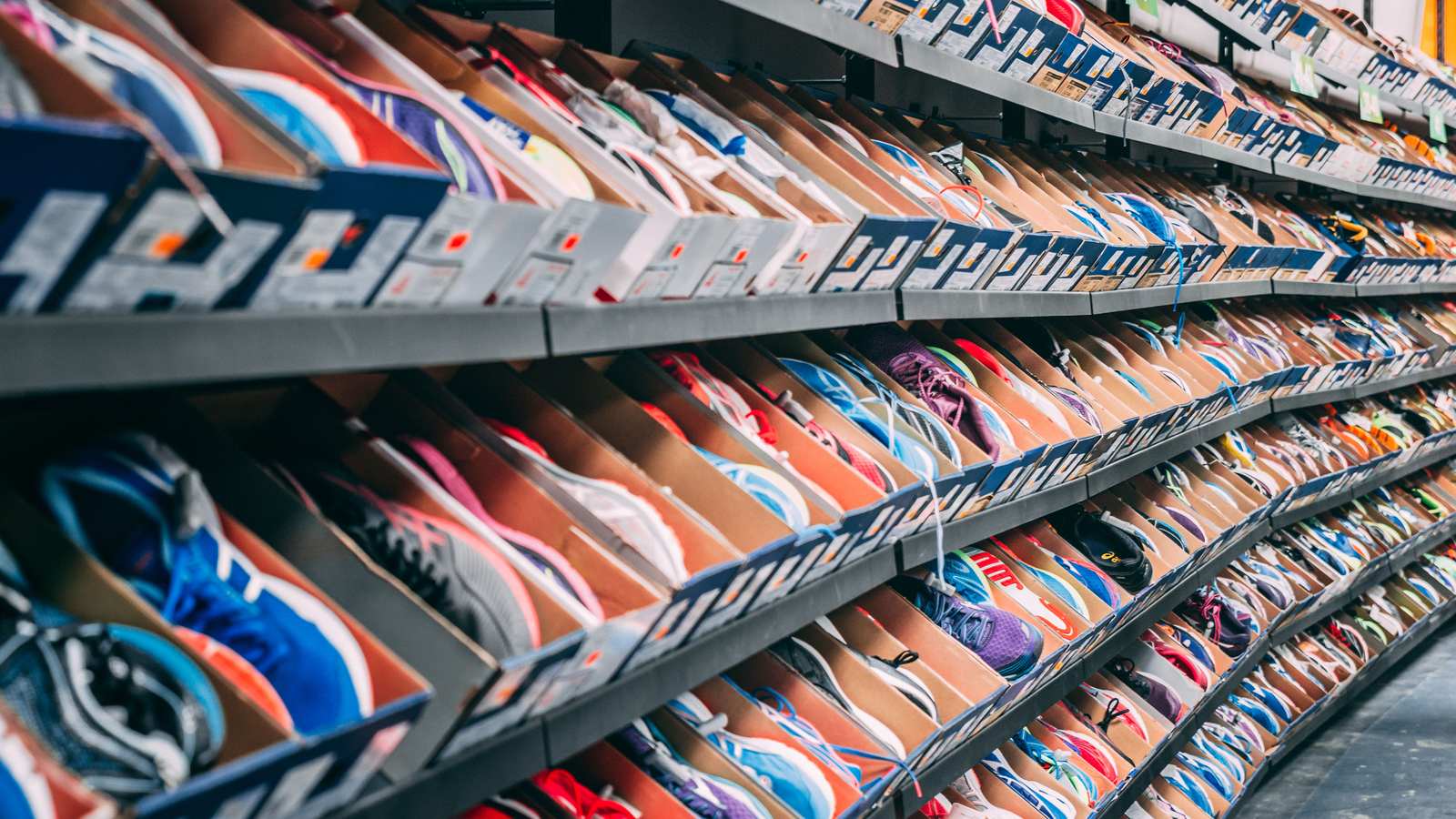 Long mur de sneakers alignées sur les étagères d'une boutique