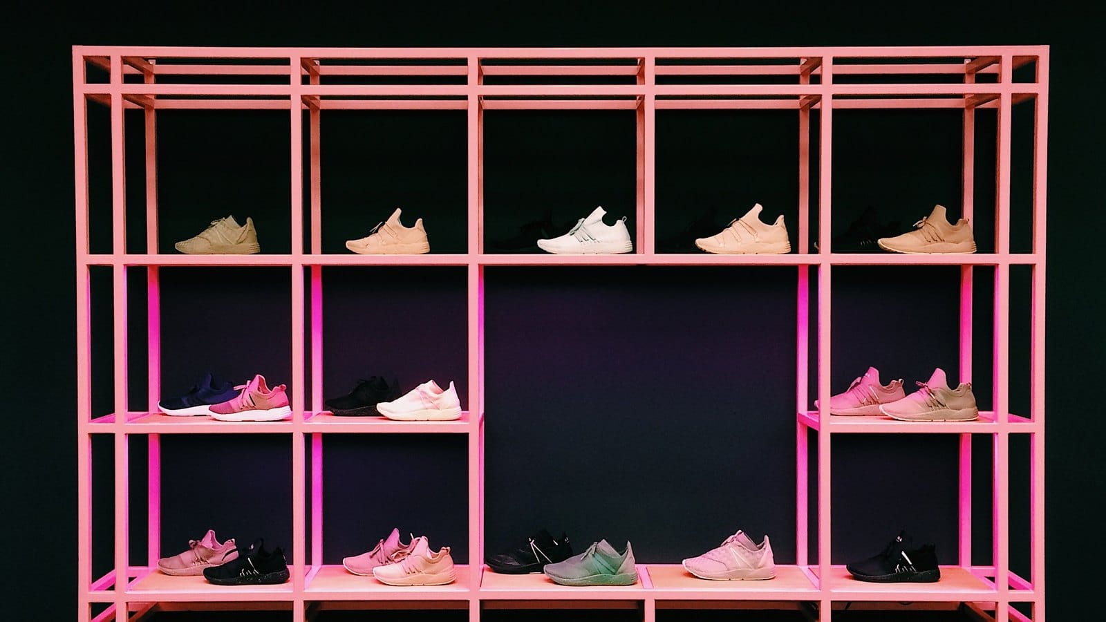 Étagères roses présentant des sneakers dans des teintes pastel